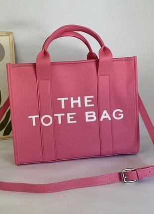Рожева жіноча сумка-шопер екошкіри  у стилі the tote bag (малинового або яскраво-рожевого кольору) з білим написом «the tote bag» на лицьовій стороні