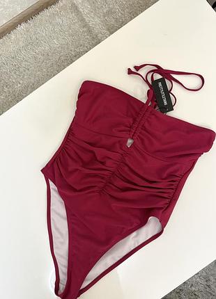Слитный купальник с драпировкой и завязками от бренда prettylittlething