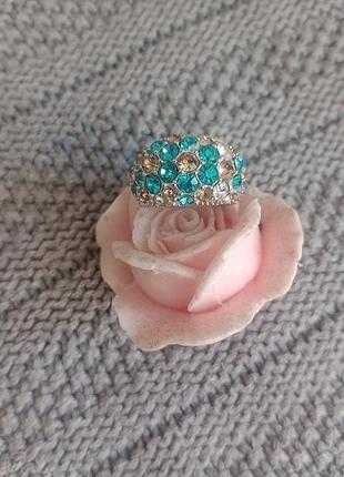 Массивное купольное кольцо (statement ring), украшенное синими (бирюзовыми/опаловыми) и золотистыми/коричневыми кристаллами или стразами