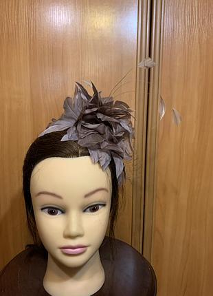 Фасинатор (fascinator), виконаний у формі декоративного композиційного капелюшка на тонкому металевому обручі (ободку).