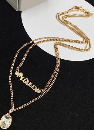 ​брендовое двухъярусное колье alexander mcqueen с надписью mcqueen и кристаллической подвеской под золото