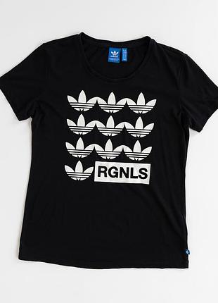 Жіноча, чорна футболка adidas originals із виразним, білим принтом, що поєднує фірмовий символ trefoil та напис rgnls. повторюваний, графічний візеру