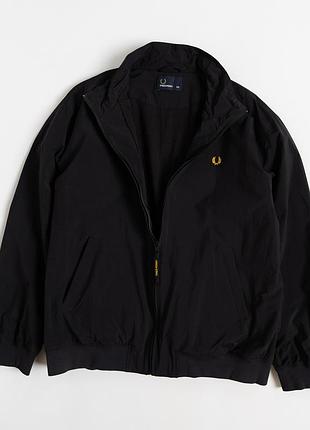 Чоловіча куртка fred perry у класичному, чорному кольорі — стримана модель, у якій британська естетика поєднується з повсякденним, спортивним стилем.