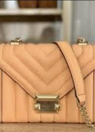 Стьобана оригінальна сумка michael kors whitney small виконана зі шкіри з фурнітурою золотистого кольору.