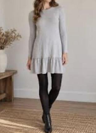 Сіра трикотажна сукня від бренду zara (лінія zara knit) з опущеною талією та плісированим або розширеним воланом знизу.