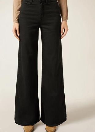Черные женские широкие джинсы с завышенной талией (в стиле wide-leg / culottes) с необработанным краем штанин.