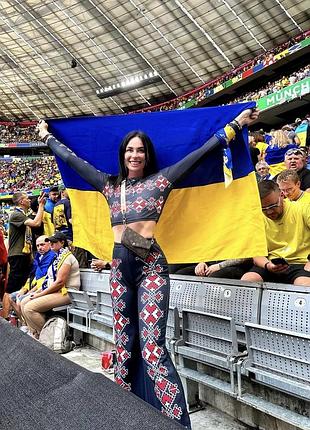 Жіночий комплект у етностилі, що складається з обтислого лонгсліва та розкльошених штанів з геометричною вишивкою.