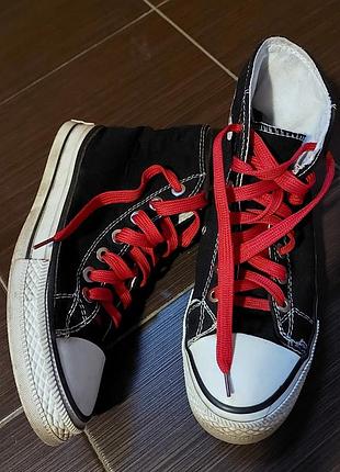Высокие черные кеды с белым носком и яркими красными шнурками

 модель converse chuck taylor all star.