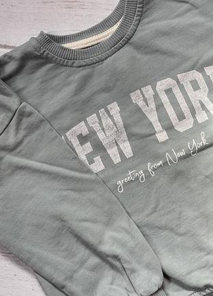 Світшот зелено-сірого кольору з написом «new york» та рукописним підписом «greeting from new york».