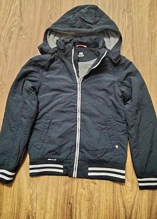 Темно-синяя куртка-ветровка (стилизованная под бомбер) от бренда h&amp;m с капюшоном и характерными белыми полосами на манжетах и резинке снизу.рос 16