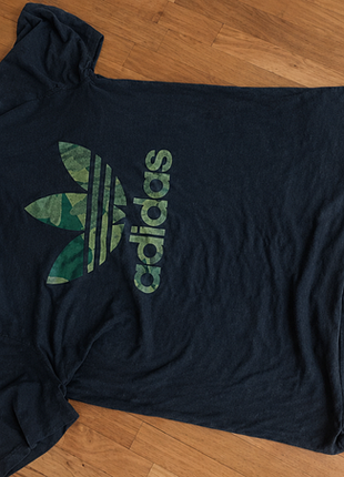 Adidas t-shirt original

стильна чорна футболка adidas із великим фірмовим логотипом у зеленому камуфляжному дизайні.