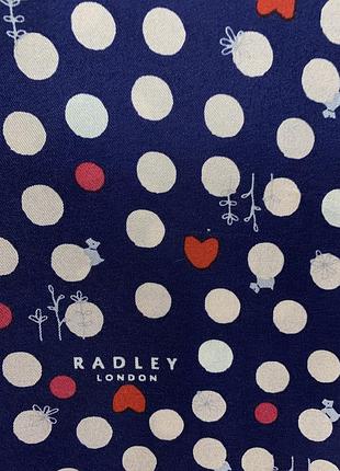Шовковий шарф від британського бренду radley london, відомого своїм фірмовим стилем і впізнаваними акцентами.