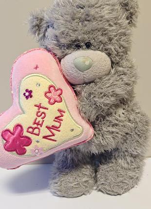 Серый плюшевый мишка tatty teddy (me to you) с голубым носиком и латками, который держит в лапах розовое сердце с надписью «best mum»