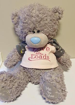 Сірий плюшевий ведмедик me to you (tatty teddy) з блакитним носиком, одягнений у білу футболку з написом «love you loads» та сірі жилетку/рукави
