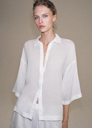Полупрозрачная белая льняная блуза-рубашка бренда zara.