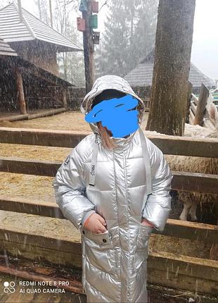 Зимова стьобана куртка для дівчинки срібляста довга з капюшоном