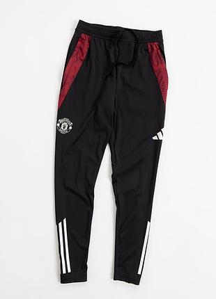 Чорні, спортивні штани adidas із символікою manchester united — поєднання футбольної спадщини та сучасного, спортивного стилю. модель доповнена конт