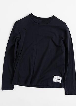 Лаконічний, чорний лонгслів від jil sander — втілення стриманої естетики, у якій головну роль відіграють силует, пропорції та увага до деталей. модель