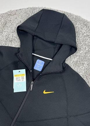 Чорне худі nike nocta на блискавці з капюшоном. модель має простий силует.