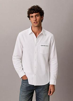 Белая мужская рубашка бренда calvin klein jeans выполнена из мягкой трикотажной ткани.