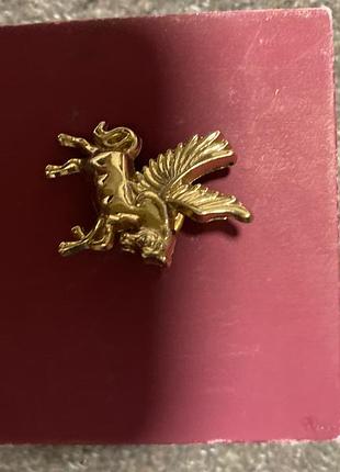 Значок, брошка-значок (пін) у формі міфічного крилатого коня пегаса.