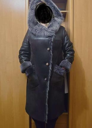 Дубленка с меховым капюшоном и накладными карманами.