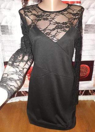 Нарядне чорне плаття із ажурними рукавами і декольте.