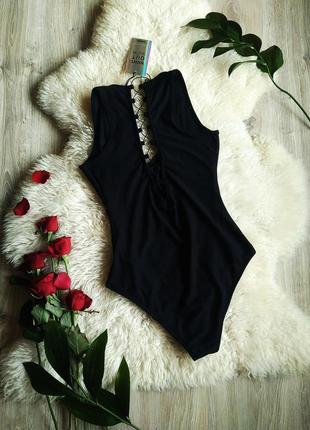 Чорний боді з шнурівкою на спині .