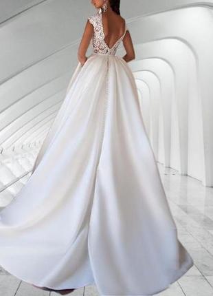 Длинное свадебное платье со шлейфом пышной атласной юбки и открытой спиной2 фото