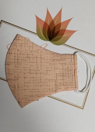 Маска нежно персиковогоцвета с интересным принтом, смотрится очень нежно.