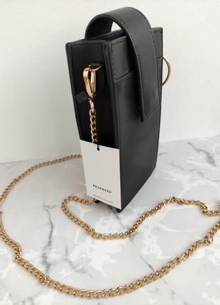 Новая черная сумочка-чехол на золотом ремешке reserved.10 фото