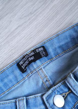 Голубые джинсы на высокой посадке на талию с фабричными рваностями6 фото