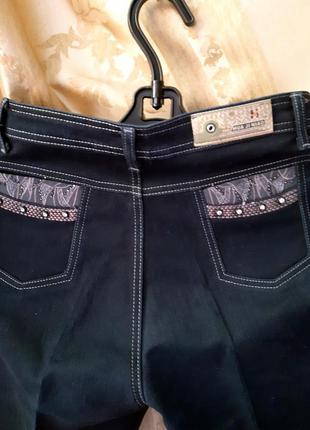 Женские  прямые темно-синие джинсы с вышивкой и стразовыми клепками.2 фото