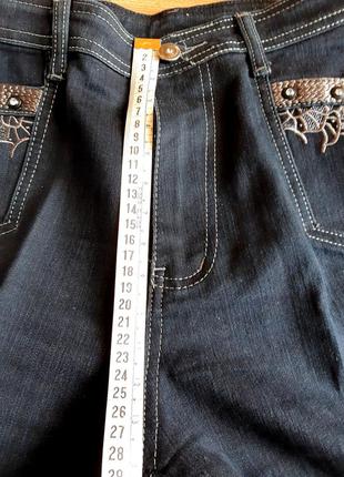 Женские  прямые темно-синие джинсы с вышивкой и стразовыми клепками.6 фото