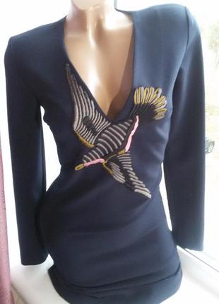 Платье с вышивкой в виде парящей птицы на груди.