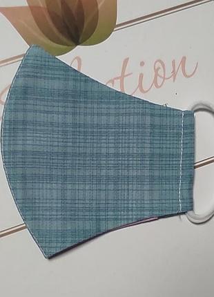 Маска приятного нейтрально голубого цвета с принтом клеточки.