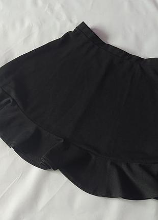 Практична чорна шкільна спідниця з оборкою
