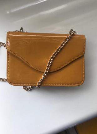 Зручна, маленька, лакова сумка через плече.