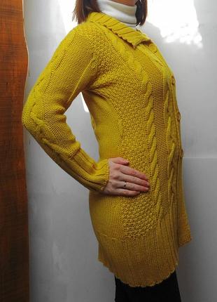 М'який кардиган з великими косами гірчичного кольору.
