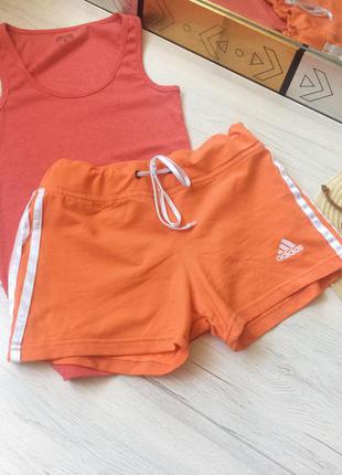 Красивые оранжевые короткие спортивные шорты с лампасами от бренда adidas1 фото