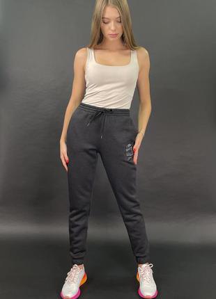 Утеплені жіночі темно-сірі штани з настрочними емблемою трехнитка на флісі