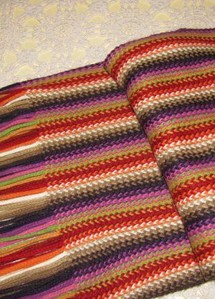 Яскравий шарф із китицями.