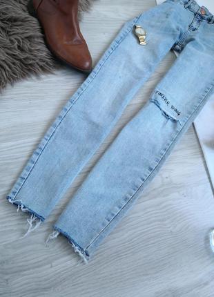 Винтажные голубые джинсы с фабричными рваностями и необроботанным низом с рисунками на высокой посадке на талию5 фото
