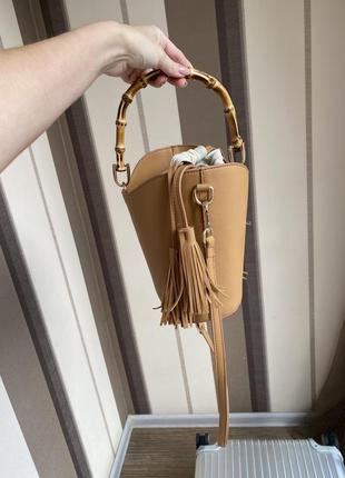 Шкіряна бежева сумочка / сумка діжечку з бамбуковою ручкою та пензликами2 фото