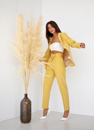 Женский однотонный брючный костюм желтый: пиджак и зауженные брюки с широким поясом  42, 46, 482 фото