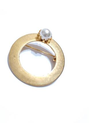 Круглая брошь с вставкой под жемчуг.