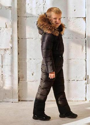 Дитячий однотонний зимовий комбінезон чорного кольору і опушкою з натурального хутра