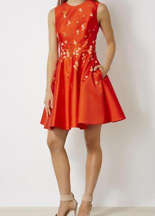 Красное платье для выпускного с цветочной аппликацией. ткань плотная и держит форму, чем формирует силуэт.