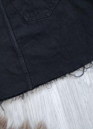 Крутая плотная черная джинсовая юбка с необработанным низом и фабричными рваностями.4 фото