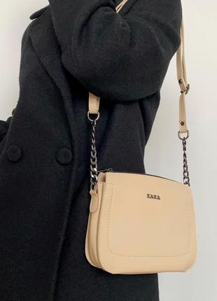 Сумка бежевого кольору через плече